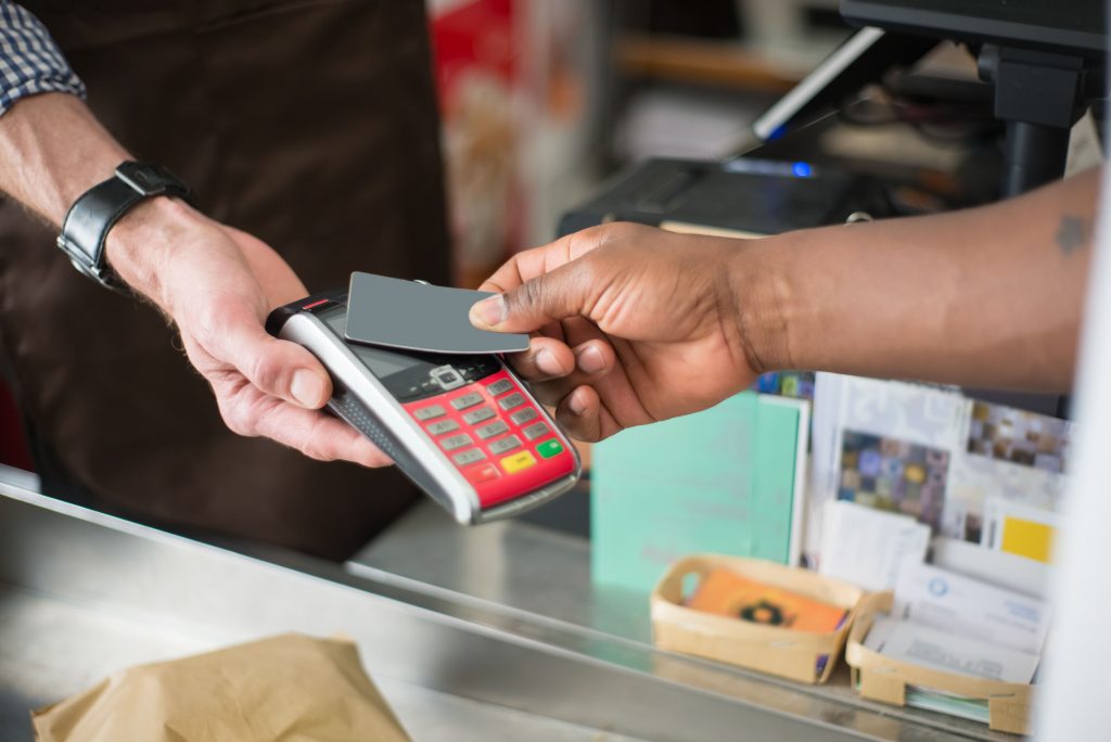 Foto van retailorganisatie die een klant in de winkel laat betalen via de kaart met een digitale kassa